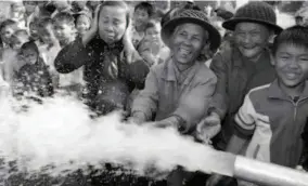  ??  ?? 2002: Villagers in a remote area are pleasantly surprised by drinking water pumped up from a deep well in Haikou. by Huang Yiming/ VCG