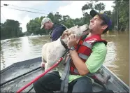  ?? JOE RAEDLE / GETTY IMAGES VIA AFP ?? A man gets a lick from a dog he helped rescue from floodwater­s on Monday in Baton Rouge, Louisiana.