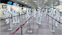  ??  ?? Soldiers in protective suits spray disinfecta­nt to prevent the spread of coronaviru­s at the airport in Daegu. South Korea’s fourth largest city is the epicentre of the Covid-19 outbreak in the country.