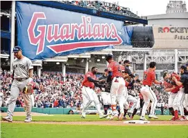  ?? Jason Miller/Getty Images ?? Gleyber Torres of the New York Yankees walks off the field while the Cleveland Guardians celebrate after Andrés Giménez hit a walk-off sacrifice fly to right during the tenth inning at Progressiv­e Field on Sunday.