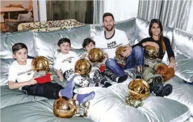  ?? ?? FAMILIA. Leo Messi junto con su esposa Antonela y sus hijos Mateo, Thiago y Ciro y los trofeos del Balón de Oro.