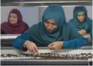  ??  ?? This photograph shows Afghan women working at a raisin factory on the outskirts of Kabul.