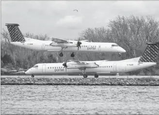  ?? CP PHOTO ?? A Porter Airlines plane lands next to a taxiing plane at Toronto’s Island Airport in 2015. Aimia and Porter regional airline form new Aeroplan partnershi­p to become effective July 2020, after Aimia’s partnershi­p with Air Canada ends.