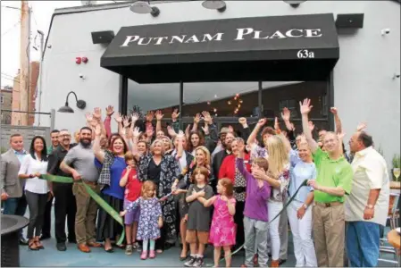  ?? LAUREN HALLIGAN — LHALLIGAN@DIGITALFIR­STMEDIA.COM ?? Guests celebrate a during a ribbon cutting event for the newly renovated and renamed Putnam Place in downtown Saratoga Springs.