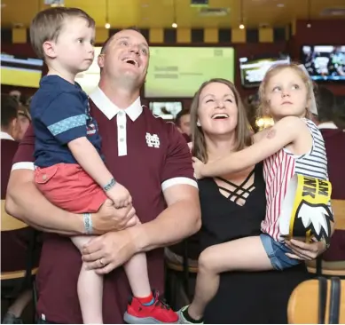  ?? (Photo by Kelly Price, MSU athletic media relations, for Starkville Daily News) ?? Mississipp­i State baseball coach Andy Cannizaro and his family watch the NCAA Selection Show at Buffalo Wild Wings Monday.