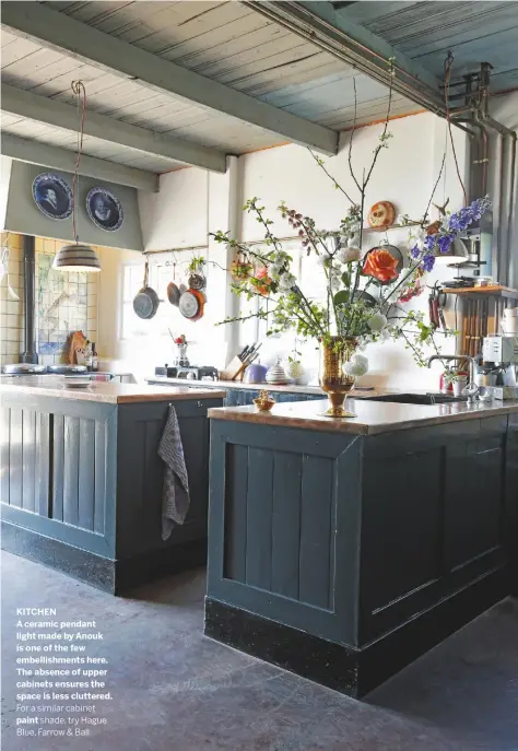  ??  ?? KITCHEN
A ceramic pendant light made by Anouk is one of the few embellishm­ents here. The absence of upper cabinets ensures the space is less cluttered.
For a similar cabinet
paint shade, try Hague Blue, Farrow & Ball