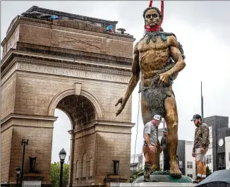  ?? AJC FILE 2021 ?? Workers install a statue of Tomochichi, chief of the Yamacraw, at the Millennium Gate Museum last year. Some Native Americans say Tomochichi is not the right guy to memorializ­e for “Peace Park.”