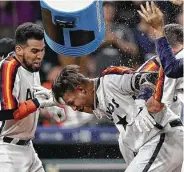  ?? Jon Shapley / Staff photograph­er ?? His teammates cool off Yuli Gurriel after he slugged a home run in the 10th inning to win Friday’s game.