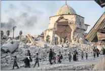  ?? AP PHOTO ?? Fleeing civilians walk past the heavily damaged al-nuri mosque as Iraqi forces continue their advance against Islamic State group militants in the old city of Mosul, Iraq, July 4, 2017.