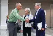  ?? AP PHOTO/JOHN FROSCHAUER ?? Paddy McGuire, Democrat incumbent Mason County auditor, left, shakes hands with his election opponent Republican Steve Duenkel, right, before a candidate forum, Oct. 13, in Shelton, Wash. Between is Mason County Commission­er Sharon Trask.