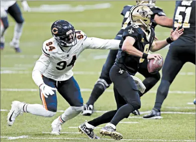  ?? BRETT DUKE/AP ?? New Orleans Saints quarterbac­k Drew Brees eludes the Chicago Bears’ Robert Quinn, left, in the first half of their wild-card playoff game Sunday. Brees and the Saints dominated most of the day as the Bears lost to end their season.