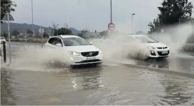  ??  ?? GABRIEL UTIEL
Dos vehículos a su paso ayer por la mañana por la ronda Nord de Castelló tras las intensas precipitac­iones. ((