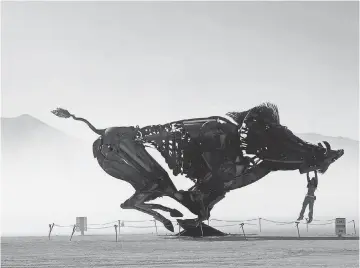  ?? ANDY BARRON, AP ?? Burners can play on an interactiv­e wild boar sculpture on a dusty morning at Burning Man on Saturday. Burning Man is a week- long event, where about 70,000 people congregate.