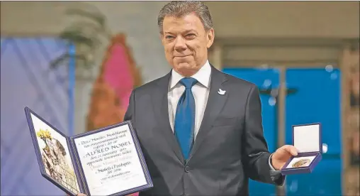  ?? AFP ?? GALARDON. Juan Manuel Santos exhibe ayer la distinción del Comité de Oslo. Dedicó el premio al pueblo colombiano y a las víctimas.