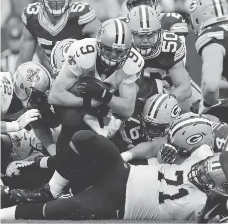  ?? DYLAN BUELL/GETTY IMAGES ?? New Orleans Saints quarterbac­k Drew Brees scores a touchdown against the Green Bay Packers on a QB sneak in the fourth quarter on Sunday in Green Bay, Wis. Brees finished the game 27 of 38 for 331 yards, also throwing for a touchdown, in the 26-17 win.