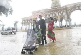  ?? J.M.VACAS ?? Una familia abandona la feria bajo la lluvia.