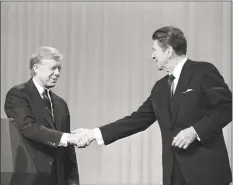  ?? Madeline Drexler / Associated Press ?? In this Oct. 28, 1980 file photo, President Jimmy Carter shakes hands with Republican Presidenti­al candidate Ronald Reagan after debating in the Cleveland Music Hall in Cleveland.