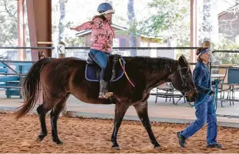  ?? Photos by Gustavo Huerta / Staff photograph­er ?? Emily Nelson is guided by volunteer Marty Cowan during an equine therapy session Thursday at Inspiratio­n Ranch, which moved to its new 40-acre location in Magnolia in 2019.