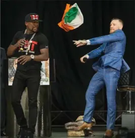  ?? RICK MADONIK, TORONTO STAR ?? Conor McGregor throws the Irish flag at Floyd Mayweather after Mayweather tried to give it to him. Mayweather and McGregor were in Toronto on a promo tour Wednesday for their Aug 26, 2017, fight in Las Vegas. The two egged each other on in front of a...