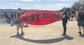  ?? ROSIE MULLALEY/THE TELEGRAM ?? Tamsyn Russell (left) and Jayne Batstone carry a “Silence is violence” banner Saturday afternoon at the Black Lives Matter NL rally at Confederat­ion Building in St. John’s.