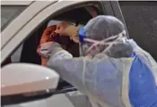  ?? AFP ?? Health workers perform nose swab tests during a drive through coronaviru­s test campaign held in Diriyah hospital in Riyadh.