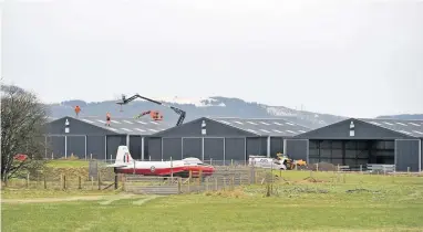  ??  ?? Work in progress A view over Balado Airfield shows staff on the roof of one hangar
