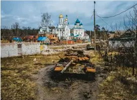  ?? IHOR TKACHOV/GETTY-AFP ?? A destroyed T-72 Russian tank sits Wednesday near Pokrovy Presvyatoy­i Bohorodyts­i Church in Svyatohirs’k, a Ukrainian city in the Donetsk region.