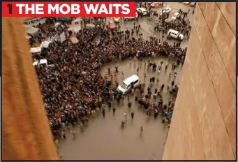  ??  ?? 1 THE MOB WAITS
BAYING: A large, all-male mob waits in the square 100 feet below the rooftop parapet where two prisoners are paraded by IS fighters