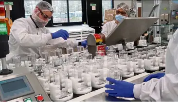  ?? —AP ?? Workers at the LVMH perfume facilities producing hydro-alcoholic gel. The French luxury conglomera­te is using its facilities to produce large quantities of hand sanitisers.