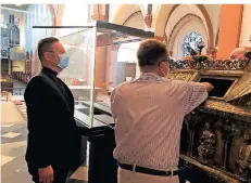  ?? FOTO: DREGGER ?? Pfarrer Oliver Dregger (links) beobachtet, wie der Suitbertus-schrein probeweise geöffnet wird.