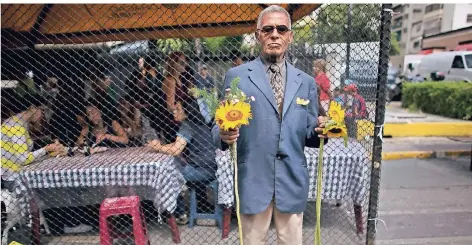  ?? FOTO: AP ?? Auf den Straßen von Caracas, Venezuelas Haupstadt, versucht ein Mann Sonnenblum­en gegen Geld oder Essen zu tauschen.