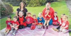  ??  ?? Owner Mel Ogle, teacher Kylie Hartland and some of the children dressed in red for the event.