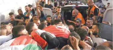  ?? Associated Press ?? ±
Palestinia­n mourners carry the body of Fayez Damdum in Al Eizariya on Saturday.