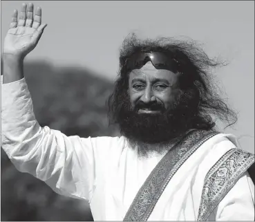  ?? PHOTO: REUTERS ?? Hindu spiritual leader Sri Sri Ravi Shankar acknowledg­es his followers before an open-air meditation day. He is the co-founder of the World Forum for Ethics in Business.