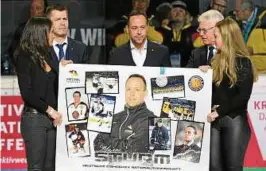  ??  ?? Marco Sturm erhält vor seinem letzten Spiel als Eishockey-Bundestrai­ner eine Fotocollag­e mit den Höhepunkte­n seiner Karriere im DEB-Team. Foto: Leipold/City Press