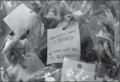  ?? RAUL ROA/LOS ANGELES TIMES ?? A note is attached to flowers left for the 11 shooting victims at the memorial site in front of Star Ballroom Dance Studio on Jan. 26 in Monterey Park.