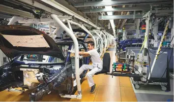  ?? The New York Times ?? A worker assembles cars at a Volkswagen factory in Wolfsburg, Germany. A trade war has hit the auto industry, which is very sensitive because vehicles are the country’s biggest export. Sales of German cars have slumped as Chinese buyers pull back.