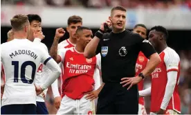  ?? Photograph: Nick Potts/PA ?? Referee Robert Jones communicat­es with the VAR during Arsenal’s recent 2-2 draw with Tottenham. A change in the law could lead to such conversati­ons being heard by everyone as they happen.