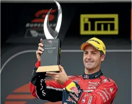  ?? PHOTO: GETTY IMAGES ?? Jamie Whincup, driver of the #88 Red Bull Holden Racing Team Holden Commodore VF, holds the Jason Richards Memorial trophy aloft after winning Auckland SuperSprin­t yesterday at Pukekohe Park Raceway.