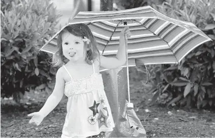  ?? AMY DAVIS/BALTIMORE SUN ?? Maizy Quinn, 21⁄ of Dundalk sticks out her tongue to catch some raindrops Thursday while on a trip with her family at The Shops at Canton Crossing. Strong storms forecast to continue into early today were expected to bring slightly cooler weather for the next few days after a weeklong heat wave. High temperatur­es in the mid-80s were forecast through the weekend.