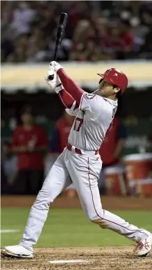  ?? ?? Yomiuri Shimbun photos
Los Angeles Angels starter Shohei Ohtani pitches against the Athletics in Oakland, Calif., on Tuesday, and as the designated hitter blasts a solo home run.
