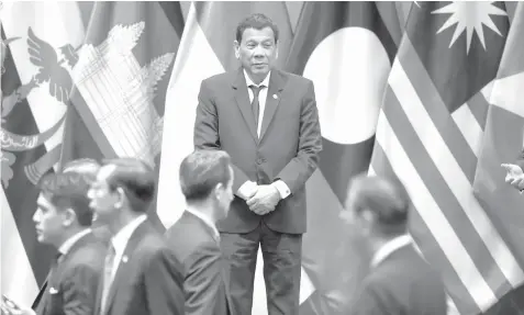  ?? AGENCE FRANCE PRESSE ?? President Rodrigo Duterte waits on stage to pose with other leaders for a group photo before the start of the ASEAN-Plus Three (APT) summit on the sidelines of the 33rd Associatio­n of Southeast Asian Nations (ASEAN) summit in Singapore.