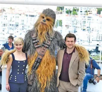  ??  ?? Emilia Clarke, a person wearing a costume of the character Chewbacca “Solo: A Star Wars Story" and Aiden Ehrenreich