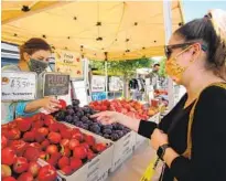  ?? KAREN PEARLMAN U-T ?? Sasha Noroozi (right) chooses fruit with the help of Rachel Petitt of Smit Farms in June.