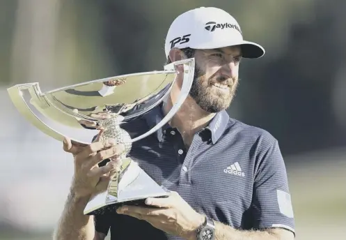  ??  ?? 0 Dustin Johnson holds the Fedex Cup trophy aloft after winning the Tour Championsh­ip at Lake Golf Club in Atlanta on Monday.