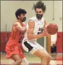  ?? David Stewart / Hearst Connecticu­t Media ?? New Canaan’s Leo Magnus (20) drives against Ridgefield’s Ben Klotz (23) during a boys basketball game at New Canaan High School on Wednesday.