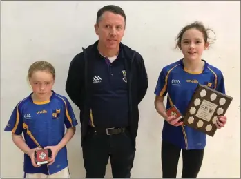  ??  ?? Ellie Murphy of Taghmon (right), girls’ Under-10 singles winner, with her clubmate Boo Murphy, the runner-up, and Robert Doyle (Juvenile Chairman).