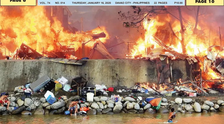  ??  ?? THIS man scrambles to save his fighting cock as fire blazed Barayco in Barangay 5-A on Wednesday morning. The Bureau of Fire in the region estimated some 60 houses gutted by flames. BING GONZALES