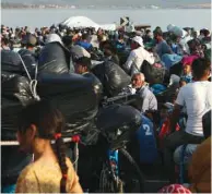  ??  ?? Refugees and migrants, from the destroyed Moria camp, line up to enter a new temporary camp, on the island of Lesbos, Greece.