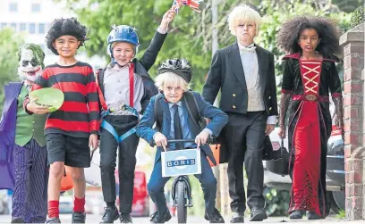  ?? PA. ?? Jack Waterson, 7, Presley Kempson and Jamison Mccarthy, both 10, take to London’s streets styled as three of the PM’S most iconic looks: Zipwire Boris, Biking Boris and Bullingdon Boris.